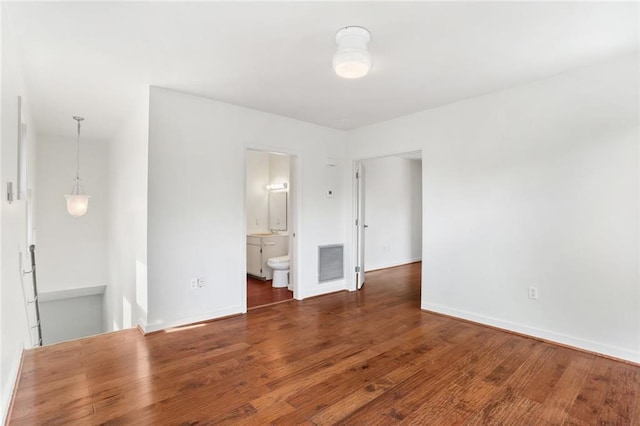 6415 Marshal Foch St, New Orleans, LA 70124 - unfurnished bedroom with wood finished floors, baseboards, and connected bathroom