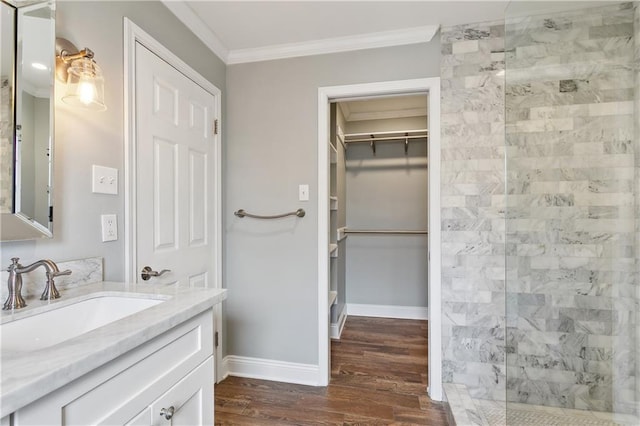 full bath with ornamental molding, a walk in shower, wood finished floors, a spacious closet, and vanity