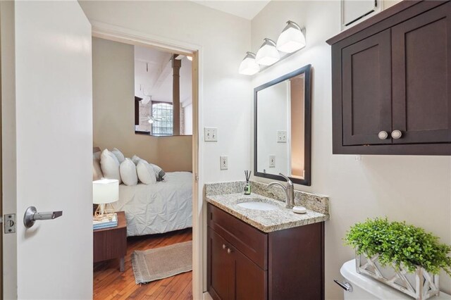 bathroom featuring wood finished floors, vanity, ensuite bathroom, and toilet