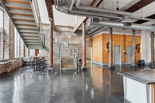 building lobby with brick wall, a towering ceiling, and stairs