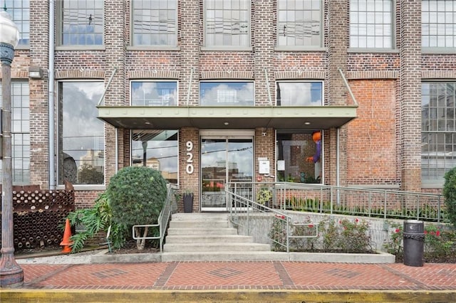 doorway to property featuring brick siding