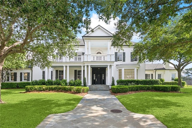 54 Beresford Dr, Metairie, LA 70001 - greek revival house featuring a balcony, a front lawn, and stucco siding