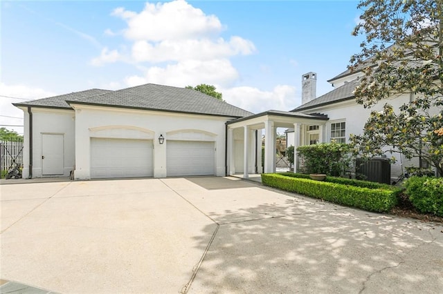 54 Beresford Dr, Metairie, LA 70001 - view of front facade with an attached garage, concrete driveway, stucco siding, and a chimney