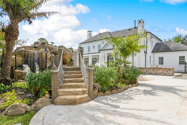 54 Beresford Dr, Metairie, LA 70001 - back of property with a chimney, stairs, and a patio area