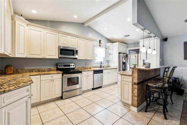 2930 Laurie Ln, Marrero, LA 70072 - kitchen featuring appliances with stainless steel finishes, a breakfast bar, light tile patterned flooring, cream cabinets, and a sink