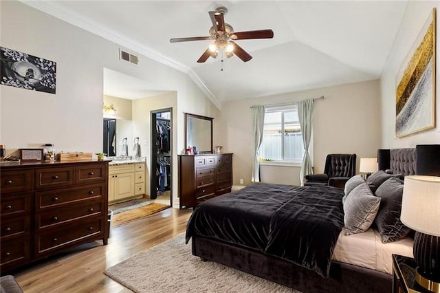 2930 Laurie Ln, Marrero, LA 70072 - bedroom with light wood-type flooring, vaulted ceiling, a walk in closet, ornamental molding, and ceiling fan