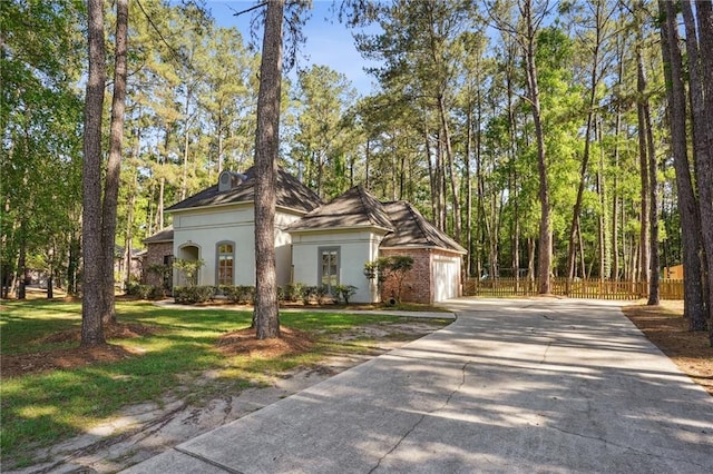 125 Secluded Forest Way, Madisonville, LA 70447 - view of front of home with driveway, stucco siding, fence, and a garage