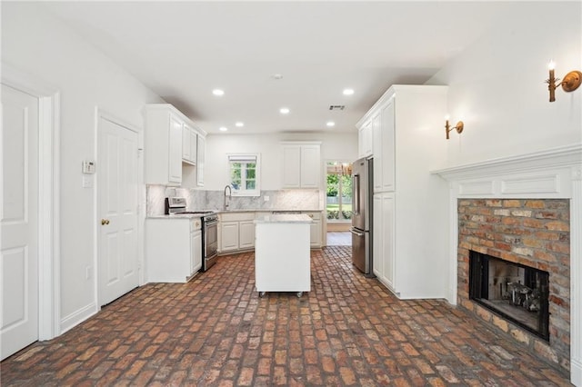 125 Secluded Forest Way, Madisonville, LA 70447 - kitchen with appliances with stainless steel finishes, brick patterned flooring, light countertops, tasteful backsplash, and a center island
