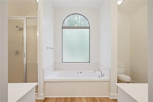 125 Secluded Forest Way, Madisonville, LA 70447 - full bath featuring wood finished floors, vanity, toilet, a stall shower, and a garden tub