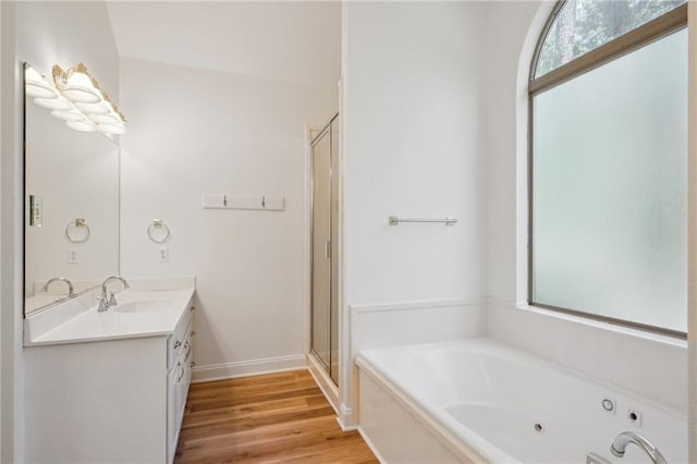 125 Secluded Forest Way, Madisonville, LA 70447 - bathroom with vanity, a shower stall, a jetted tub, wood finished floors, and baseboards