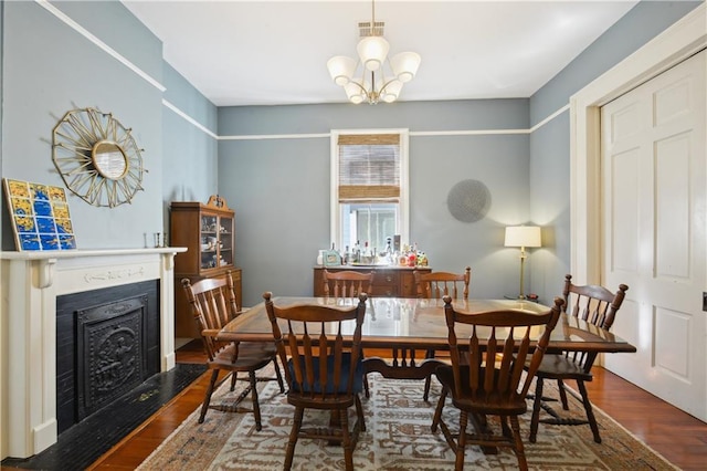 8216 Spruce St, New Orleans, LA 70118 - dining area featuring a chandelier, wood finished floors, and a fireplace