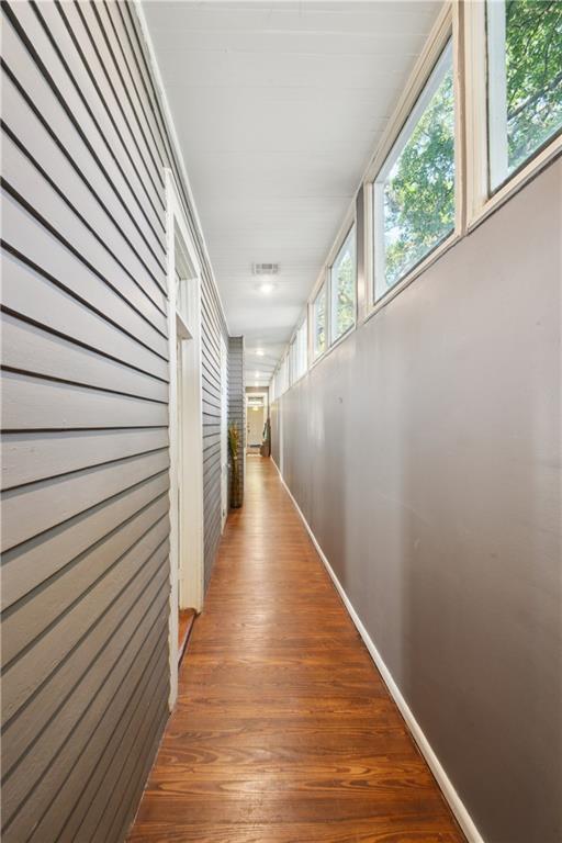 8216 Spruce St, New Orleans, LA 70118 - hallway featuring healthy amount of natural light, baseboards, and wood finished floors