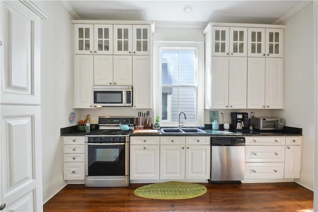 8216 Spruce St, New Orleans, LA 70118 - kitchen with stainless steel appliances, a sink, dark countertops, crown molding, and white cabinetry