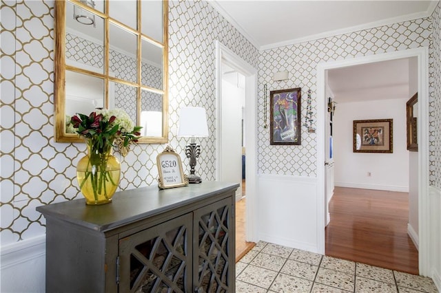 hallway featuring crown molding, wallpapered walls, and baseboards