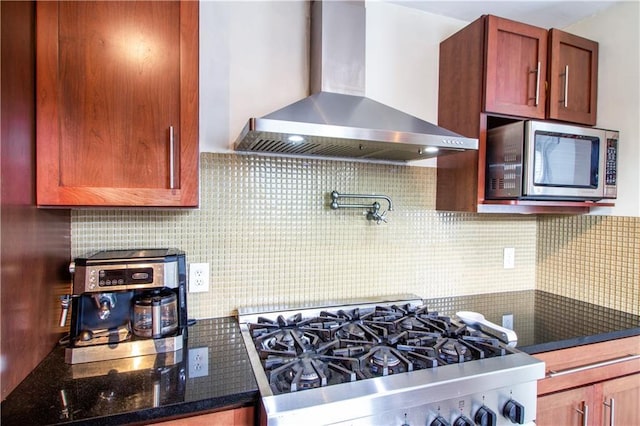 kitchen with wall chimney exhaust hood, stainless steel microwave, stove, and decorative backsplash