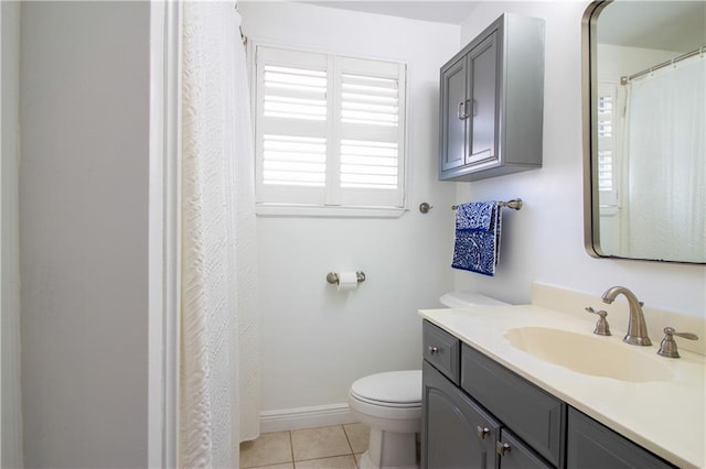 bathroom with toilet, tile patterned floors, vanity, and baseboards
