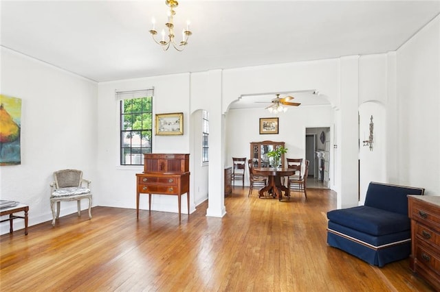 403 Athania Pkwy, Metairie, LA 70001 - living area with arched walkways, light wood-type flooring, a chandelier, and a ceiling fan
