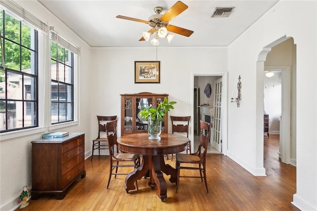 403 Athania Pkwy, Metairie, LA 70001 - dining area with ceiling fan, arched walkways, light wood-style flooring, and baseboards