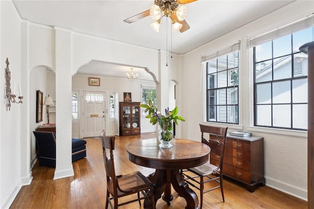 403 Athania Pkwy, Metairie, LA 70001 - dining area featuring light wood-type flooring, baseboards, arched walkways, ceiling fan, and a chandelier