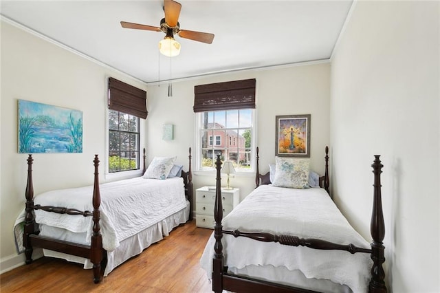403 Athania Pkwy, Metairie, LA 70001 - bedroom featuring multiple windows, ornamental molding, wood finished floors, a ceiling fan, and baseboards