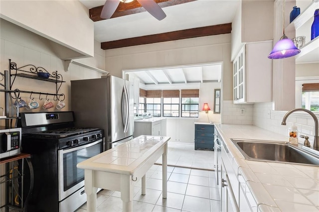 403 Athania Pkwy, Metairie, LA 70001 - kitchen with stainless steel appliances, a sink, tile counters, a ceiling fan, and plenty of natural light