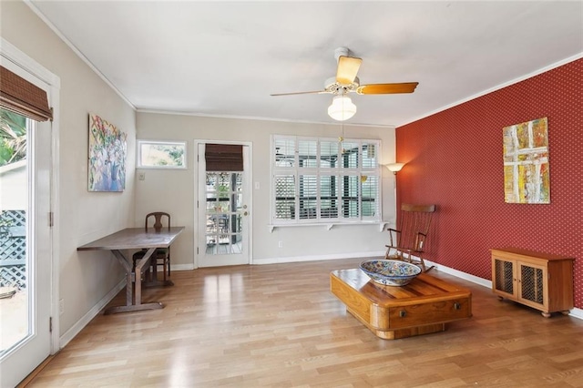 403 Athania Pkwy, Metairie, LA 70001 - living room featuring an accent wall, plenty of natural light, ornamental molding, a ceiling fan, and wood finished floors