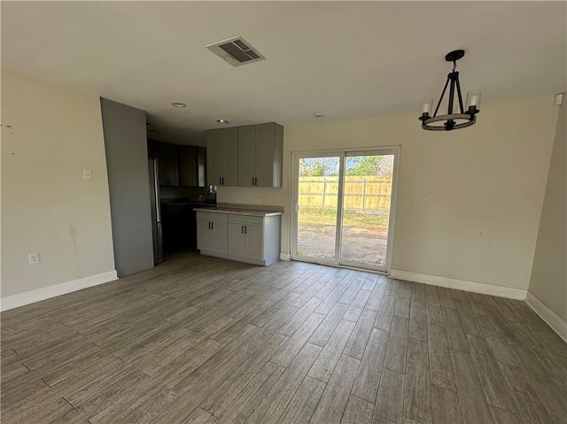 1561 Curtis St, Harvey, LA 70058 - unfurnished living room featuring wood finished floors, baseboards, and a chandelier