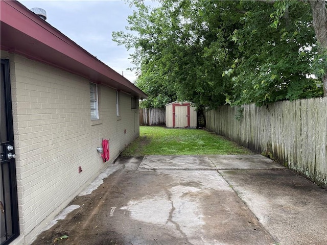 view of yard featuring a patio, a shed, and an outbuilding