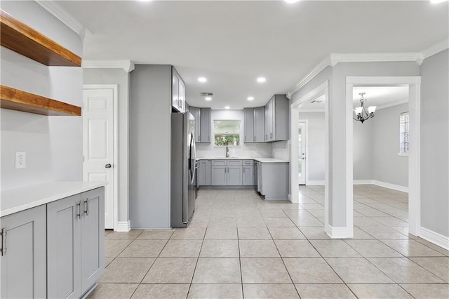 4933 Sanford St, Metairie, LA 70006 - kitchen featuring gray cabinetry, freestanding refrigerator, a sink, a chandelier, and ornamental molding