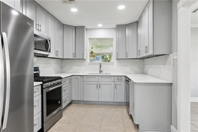 4933 Sanford St, Metairie, LA 70006 - kitchen with appliances with stainless steel finishes, gray cabinetry, a sink, recessed lighting, and tasteful backsplash