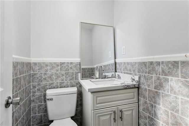 4933 Sanford St, Metairie, LA 70006 - half bathroom featuring tile walls, toilet, wainscoting, and vanity