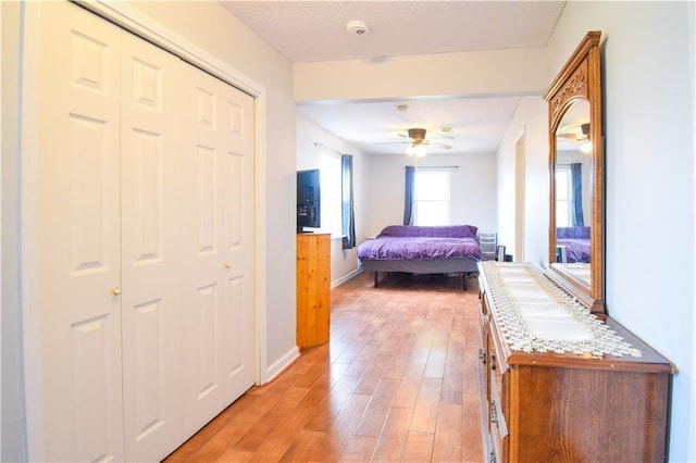 hallway featuring light wood finished floors and baseboards
