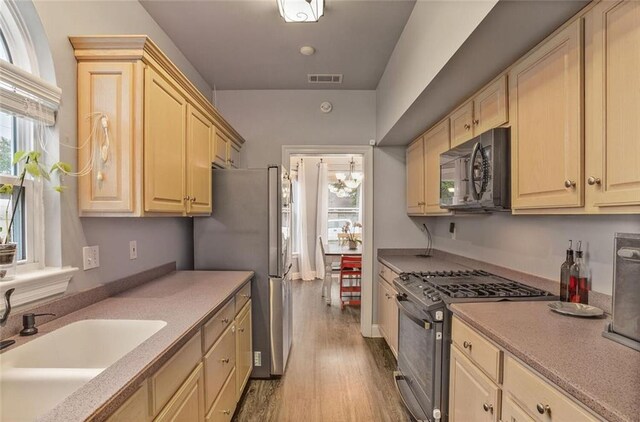 700 Kent Ave, Metairie, LA 70001 - kitchen with appliances with stainless steel finishes, a sink, light wood-type flooring, and light countertops