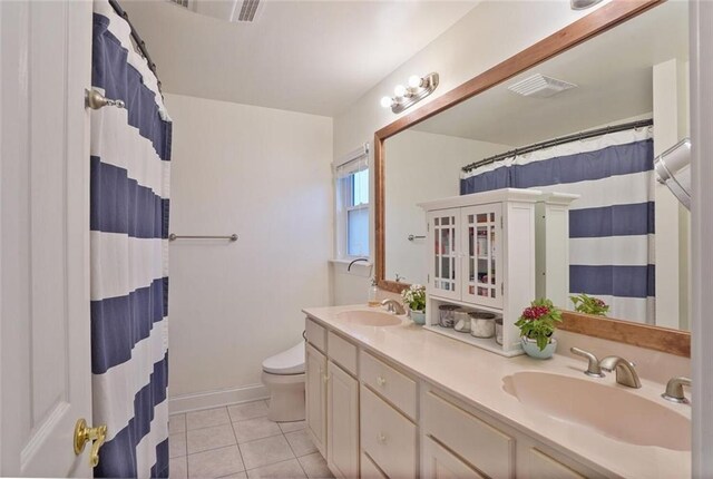 700 Kent Ave, Metairie, LA 70001 - bathroom featuring tile patterned flooring, toilet, double vanity, curtained shower, and baseboards