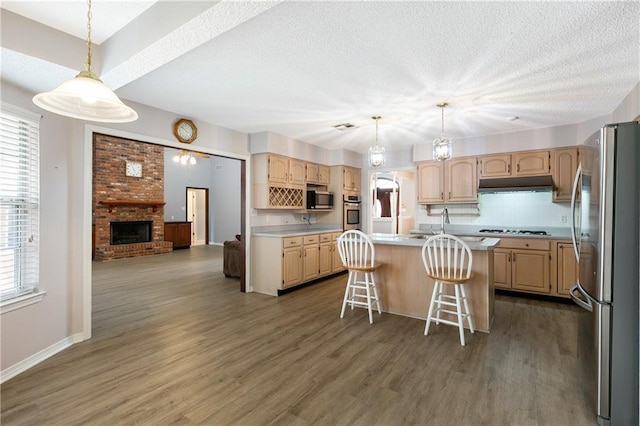 602 Willowdale Blvd, Luling, LA 70070 - kitchen featuring appliances with stainless steel finishes, under cabinet range hood, light countertops, a textured ceiling, and light brown cabinetry