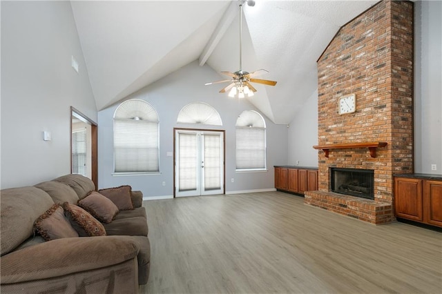 602 Willowdale Blvd, Luling, LA 70070 - living room featuring light wood-style flooring, a ceiling fan, beamed ceiling, a brick fireplace, and high vaulted ceiling