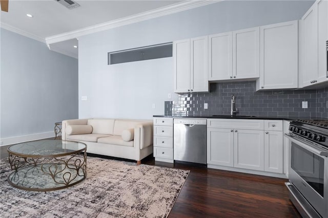 kitchen featuring appliances with stainless steel finishes, a sink, crown molding, dark wood finished floors, and decorative backsplash