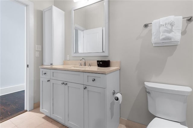 bathroom featuring toilet, vanity, tile patterned floors, and baseboards