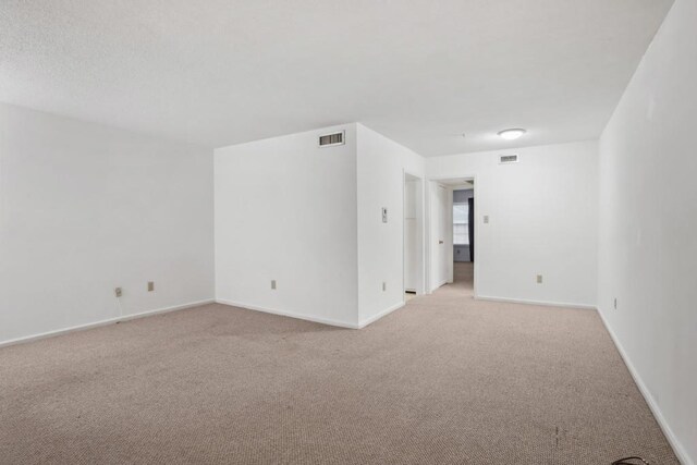 spare room with light colored carpet and baseboards
