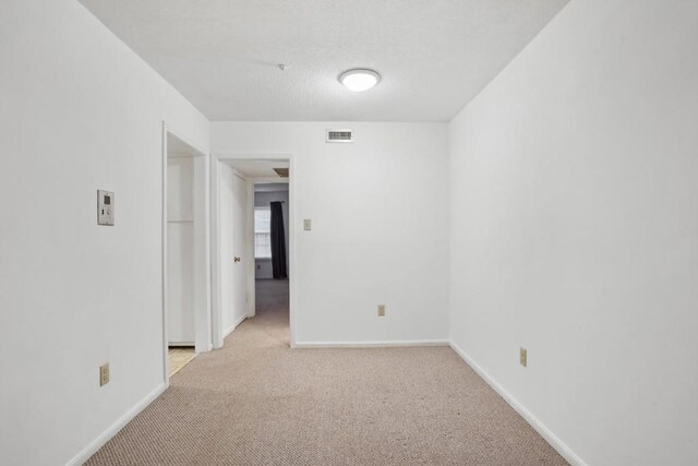 unfurnished room featuring light colored carpet and baseboards