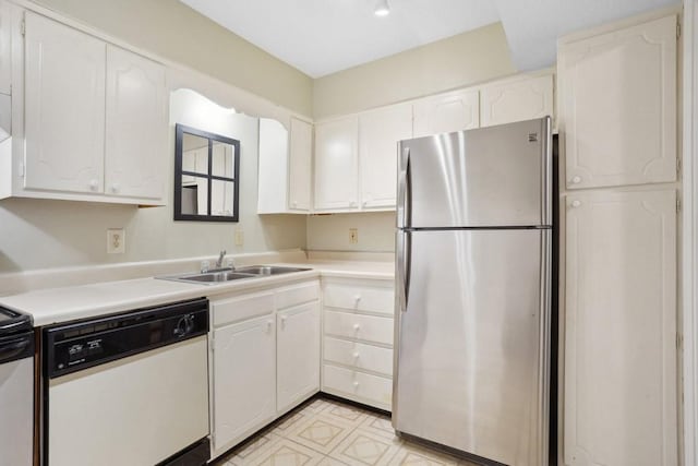 kitchen with freestanding refrigerator, dishwasher, a sink, and white cabinets