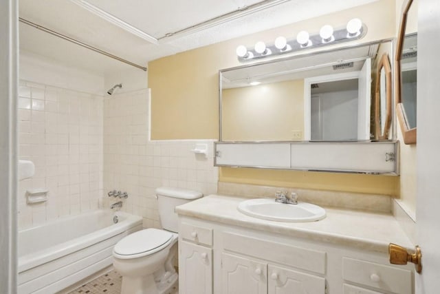 bathroom featuring toilet, bathtub / shower combination, vanity, and tile walls