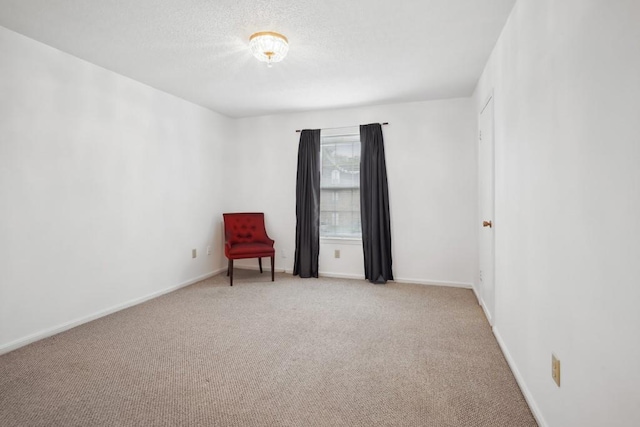 unfurnished room with carpet flooring, baseboards, and a textured ceiling
