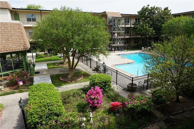 community pool with a patio area and fence