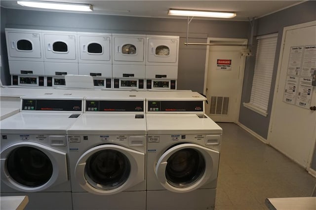 community laundry featuring washing machine and clothes dryer, stacked washer / dryer, and baseboards