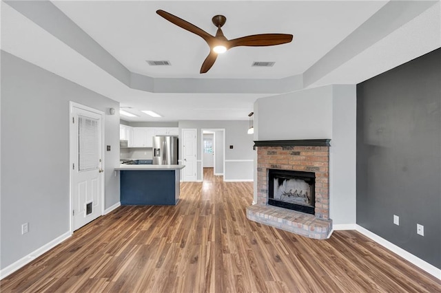 3737 James Victor Dr, Baton Rouge, LA 70817 - unfurnished living room featuring a fireplace, a ceiling fan, wood finished floors, and baseboards