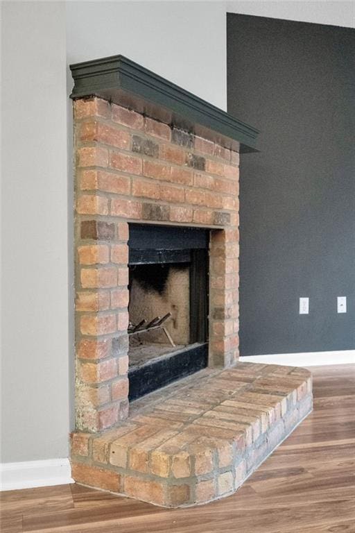 3737 James Victor Dr, Baton Rouge, LA 70817 - detailed view of baseboards, wood finished floors, and a brick fireplace