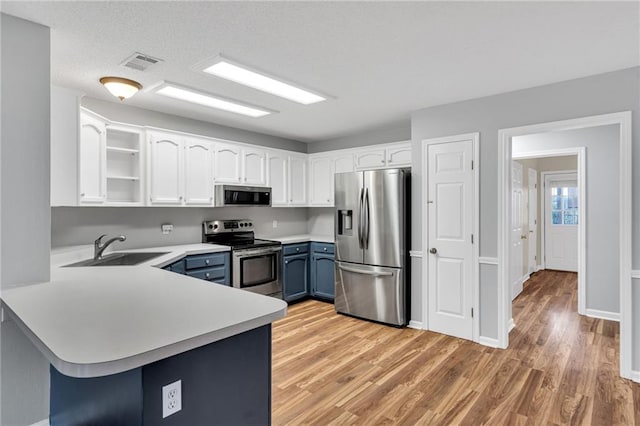 3737 James Victor Dr, Baton Rouge, LA 70817 - kitchen with appliances with stainless steel finishes, a sink, a peninsula, light countertops, and blue cabinets