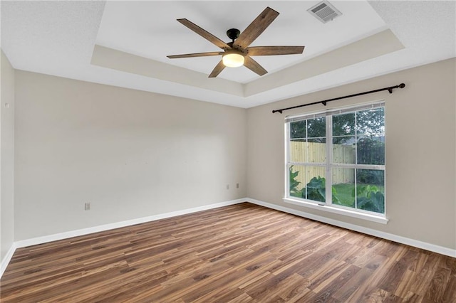 3737 James Victor Dr, Baton Rouge, LA 70817 - unfurnished room with a tray ceiling, wood finished floors, baseboards, and a ceiling fan
