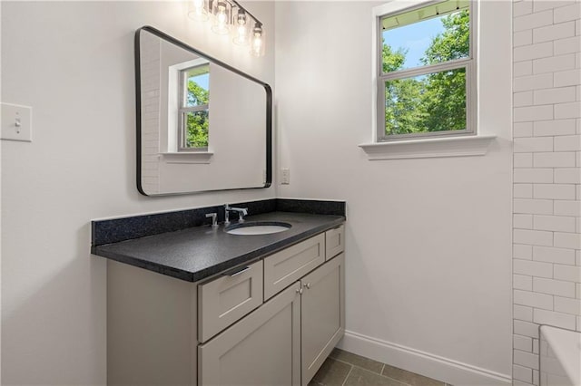 212 Highland Oak N, Madisonville, LA 70447 - bathroom featuring healthy amount of natural light, vanity, a tub, and baseboards